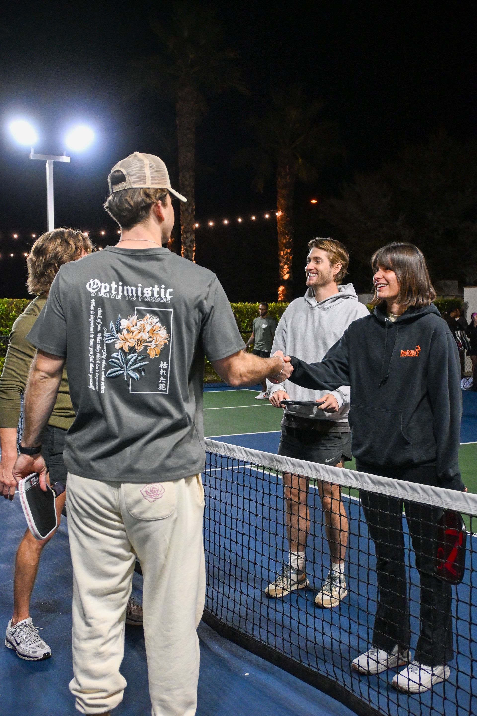 Players shaking hands across the net after a pickleball game