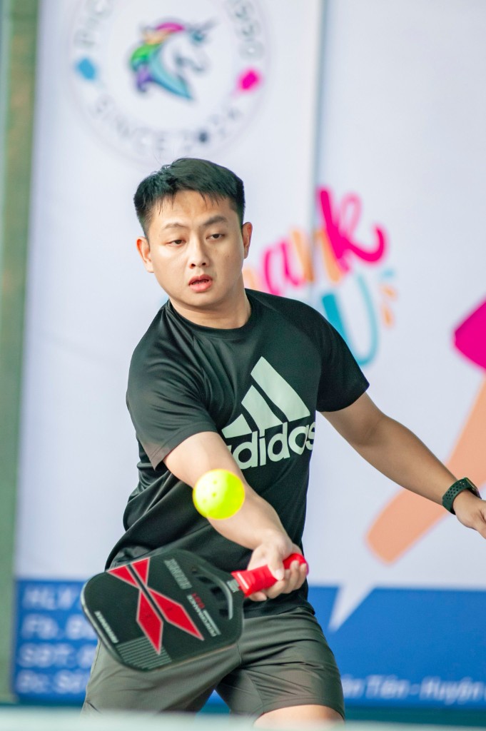 A pickleball player focused on the ball during a match