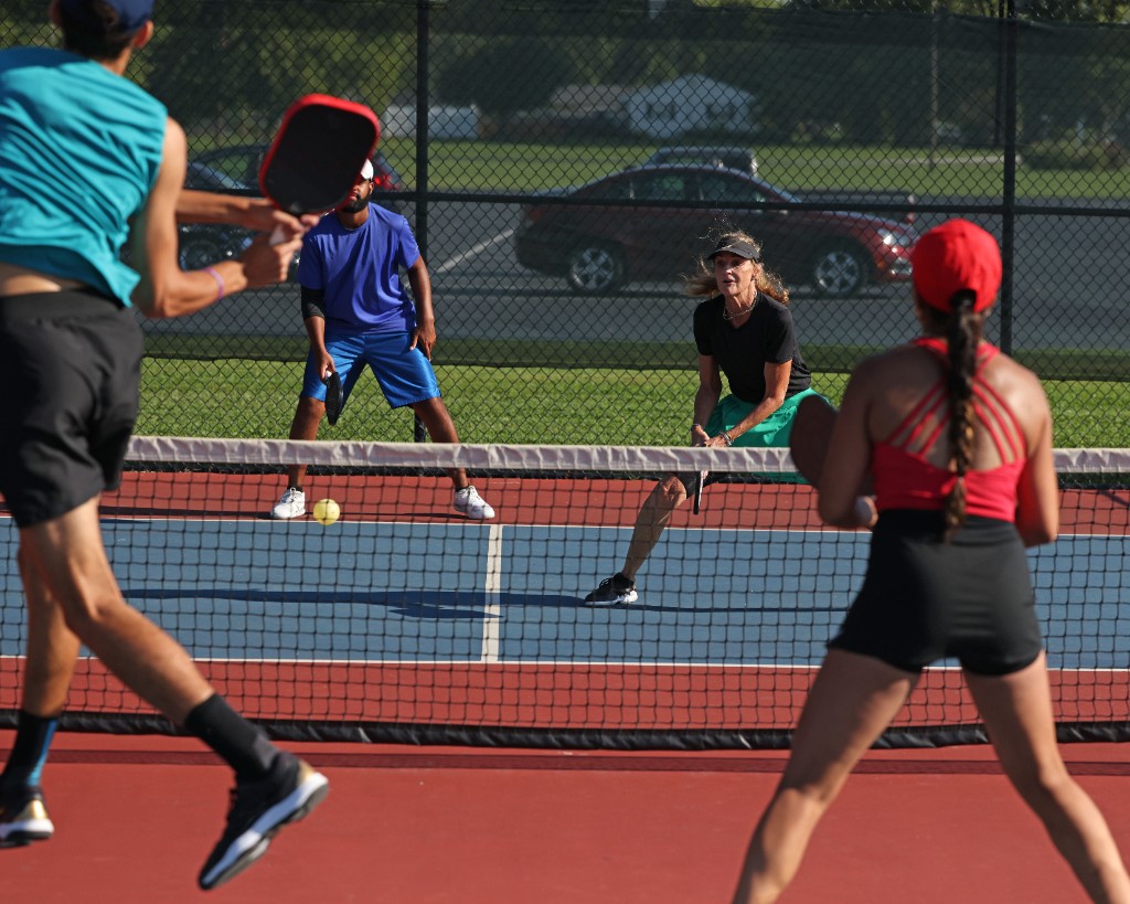 Friends playing their own pickleball game across the net